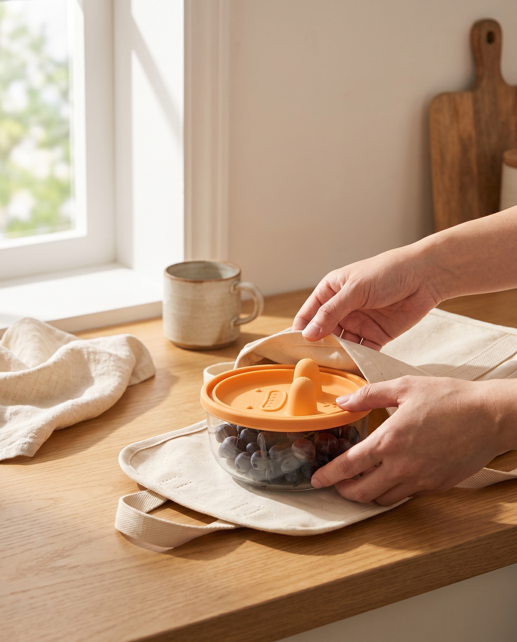 Hands sealing the snack pot full of berries on a kitchen worktop beside a canvas bag