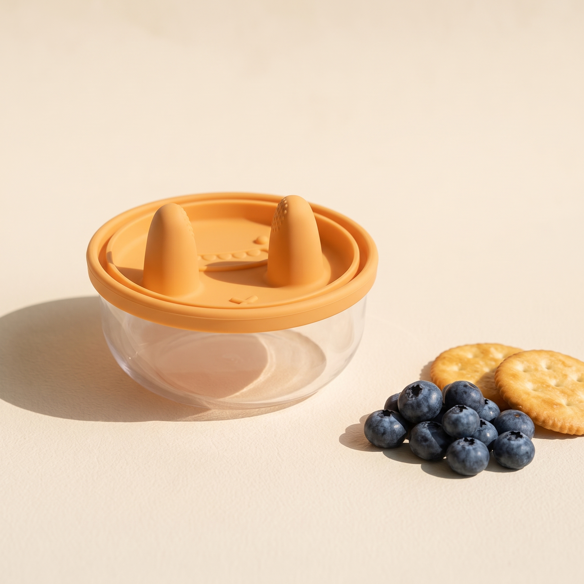 The sealed snack pot beside a small pile of blueberries and crackers