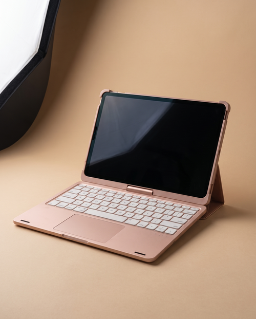 The keyboard case in rose gold, open at a laptop angle with the keyboard and trackpad visible